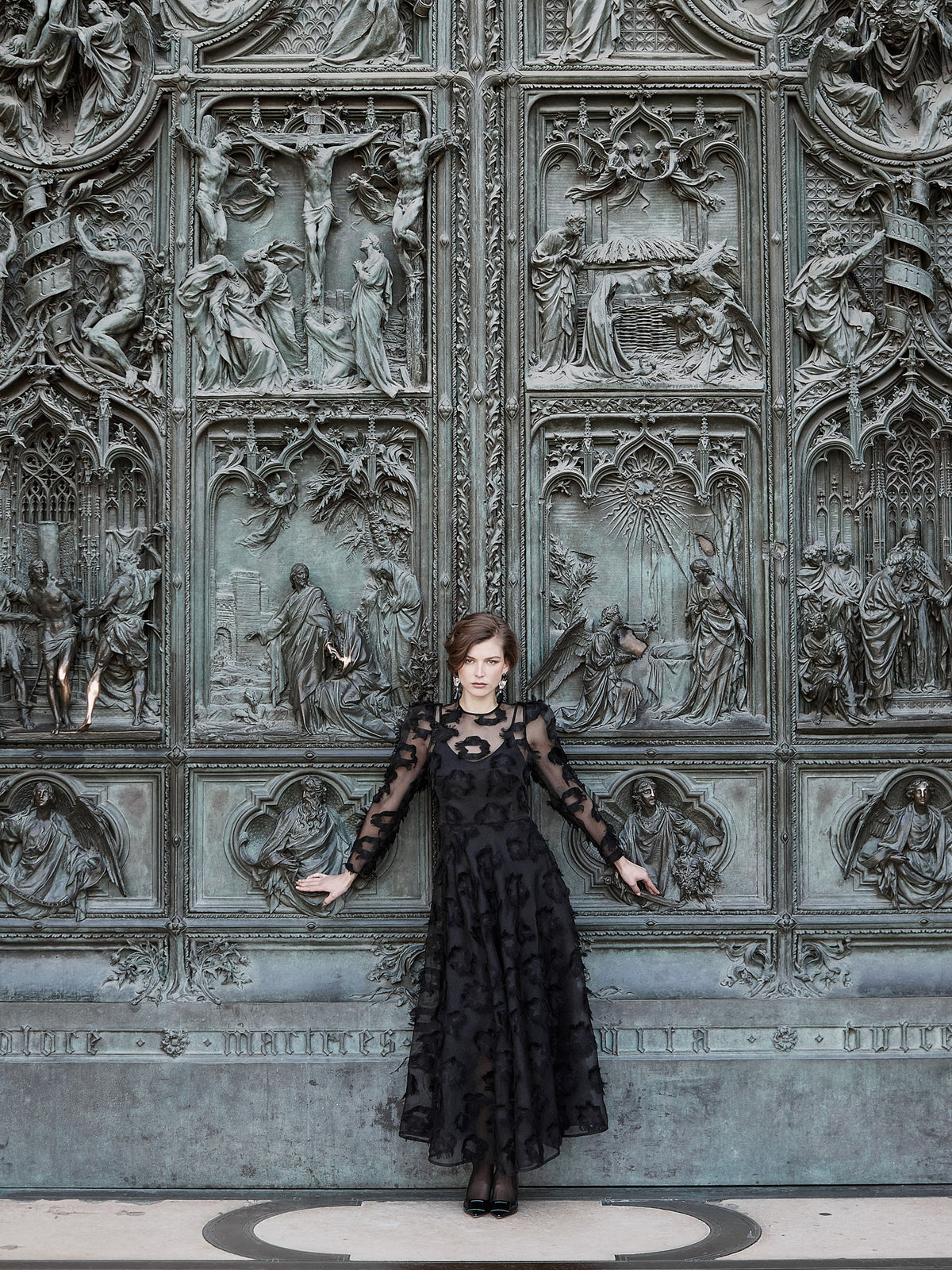 Musta kukka-applikaatioin koristeltu maksimekko, korostettu vyötärö ja nilkkaan ulottuva helma